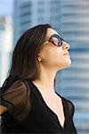 Woman wearing sunglasses, looking up, portrait