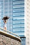 Young woman standing on balcony, tossing hair