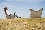 Man with laZSop computer outdoors, daydreaming