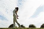 Woman outdoors standing with arms out, head back