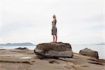 Woman Standing on a Boulder on the Beach, Vancouver, BC, Canada