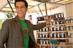 Young man with black hair putting back a preserving glass with jam, selective focus