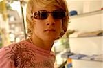 Young blond man with sunglasses in a clothes shop, close-up