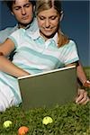 Young couple with laptop in grass