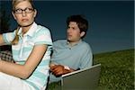 Jeune couple avec ordinateur portable en herbe
