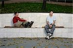 Couple d'adolescents avec patins assis sur une marche