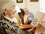 Elderly Couple in Retirement Home, Woman Working on Crossword Puzzle