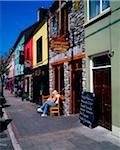 Kenmare, Co Kerry, Irlande ; Femme, manger à l'extérieur d'un restaurant traditionnel fish and chips