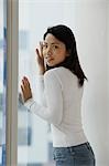 Young Asian woman looking out window