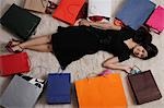 Femme chinoise pose sur plancher avec sacs à provisions
