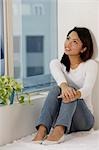 Young Asian woman looking out a window