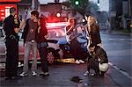 Jugendliche und Polizeibeamten am Tatort Autounfall