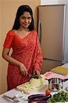 Indian woman wearing a sari while making dinner in the kitchen