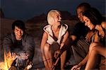 People sitting around a campfire at night