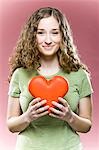 Young woman holding red heart, portrait