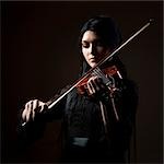 Young woman playing violin, studio shot
