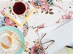 Essen und Trinken mit Brille und Papier auf floral Tischdecke