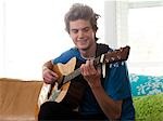 USA, Utah, Provo, junger Mann, die Gitarre spielen im Wohnzimmer