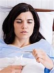 Orem, Utah, USA, junge kranke Frau im Bett, Blick auf das Thermometer.