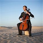 USA, Utah, Little Sahara, junger Mann mit Cello in der Wüste