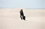 USA, Utah, Little Sahara, young businesswoman walking on desert