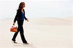 USA, Utah, petit Sahara, jeune femme marchant sur désert transportant des gaz peut