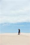 USA, Utah, Little Sahara, young businesswoman standing on desert carrying gas can