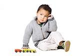 Studio portrait of boy (18-23 months) playing with toy car