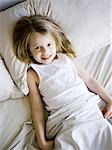 USA, Utah, Provo, Portrait of girl (4-5) lying in bed