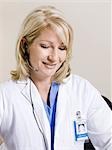 Female nurse using headset, studio shot