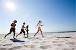 Group of adults running on the beach