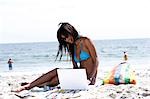 Woman with laptop at the beach
