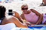 Man taking a picture of a woman at the beach