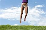 Legs of a woman in bikini jumping