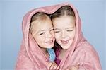 Two happy girls wrapped in a towel