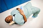 Male doctor resting on bench in scrubs