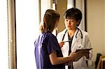Female doctor explaining patient records to nurse