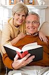 Homme d'âge mûr avec livre et de la femme mature lui étreignant
