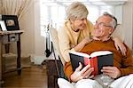 Homme d'âge mûr avec livre et de la femme mature lui étreignant