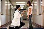 Young girl playing with female doctor's stethoscope