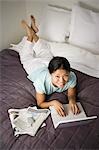 Female on bed with laptop and cell phone