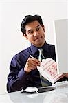 Male sitting at desk with computer and Chinese take out