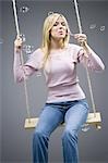 Woman blowing bubbles on swing