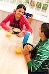 Fille qui langue sort à la table du petit déjeuner