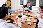 Family at dinner table toasting