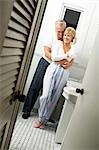 Mature couple in bathroom embracing