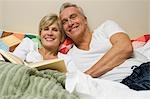 Mature couple in bed reading