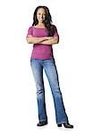 Woman in blue jeans standing with arms crossed