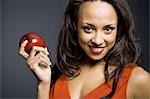 Woman with red lipstick and red apple smiling