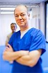 Male health care worker standing with arms crossed